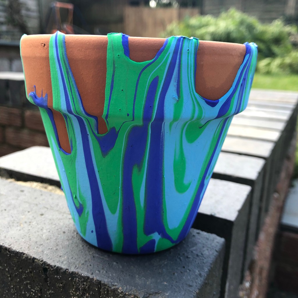 a plant pot with paint poured over it 